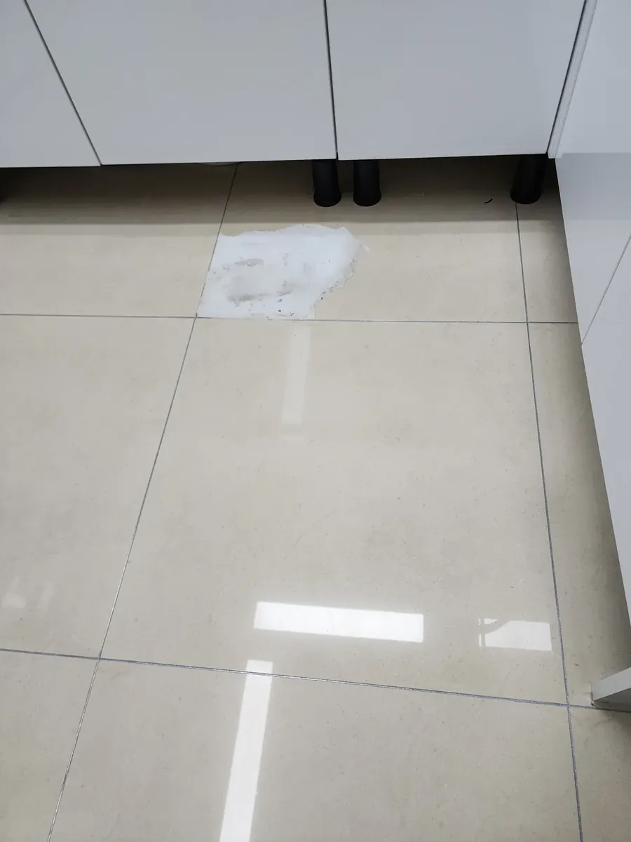 주방 바닥 타일 교체 — 싱크대 앞 흰 메움재로 덧발라 둔 타일